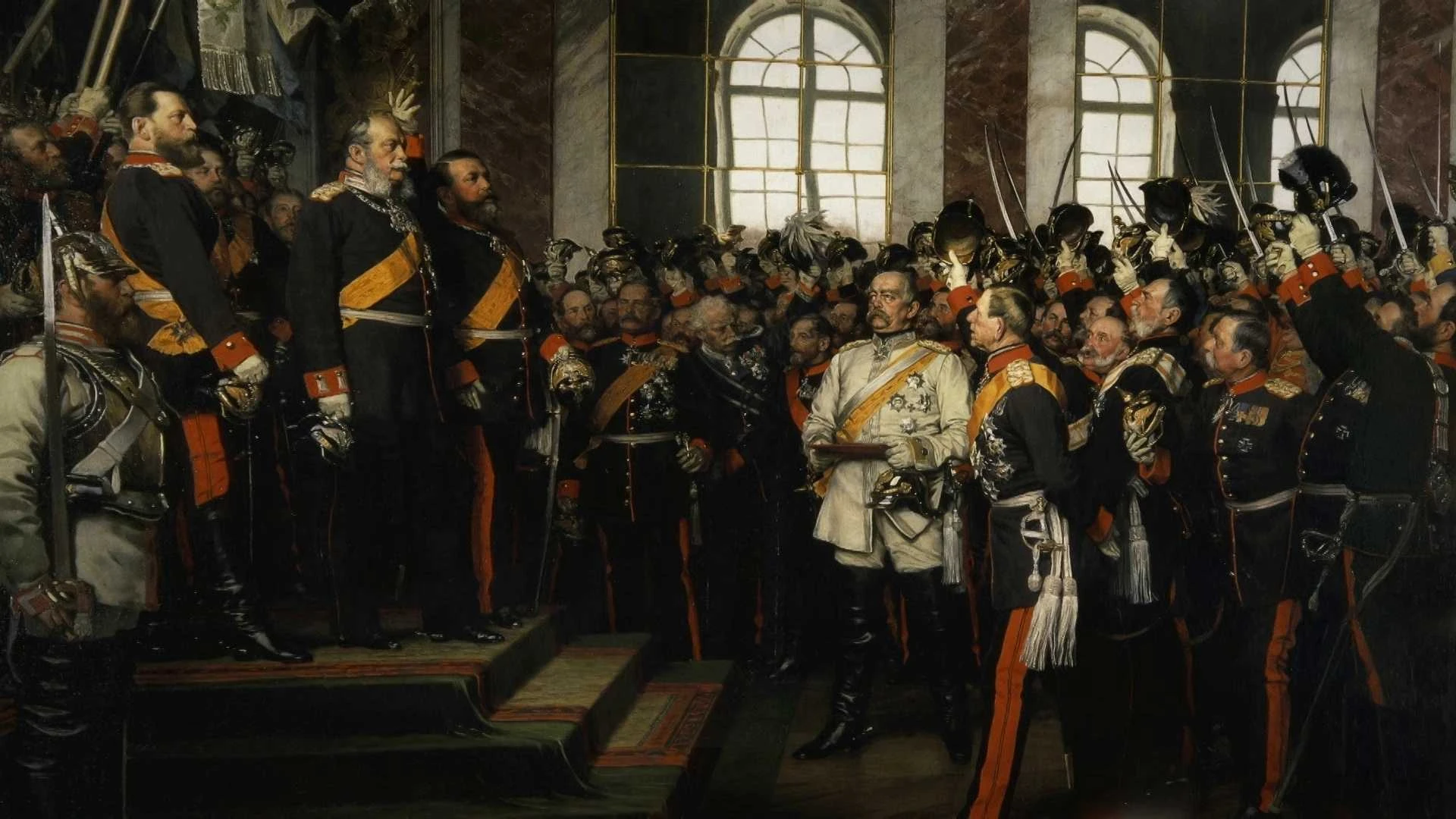 Eine große Gruppe von Männern in Militäruniformen steht in einer großen Halle, ein Mann steht auf einer Treppe, während andere zusehen oder salutieren.
