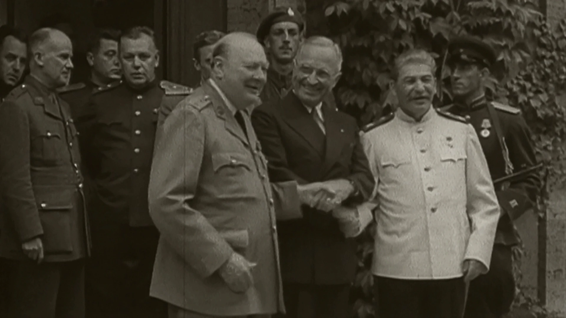Winston Churchill, Harry S. Truman und Joseph Stalin stehen während der Potsdamer Konferenz im Jahr 1945 zusammen mit Militäroffizieren vor der Tür.
